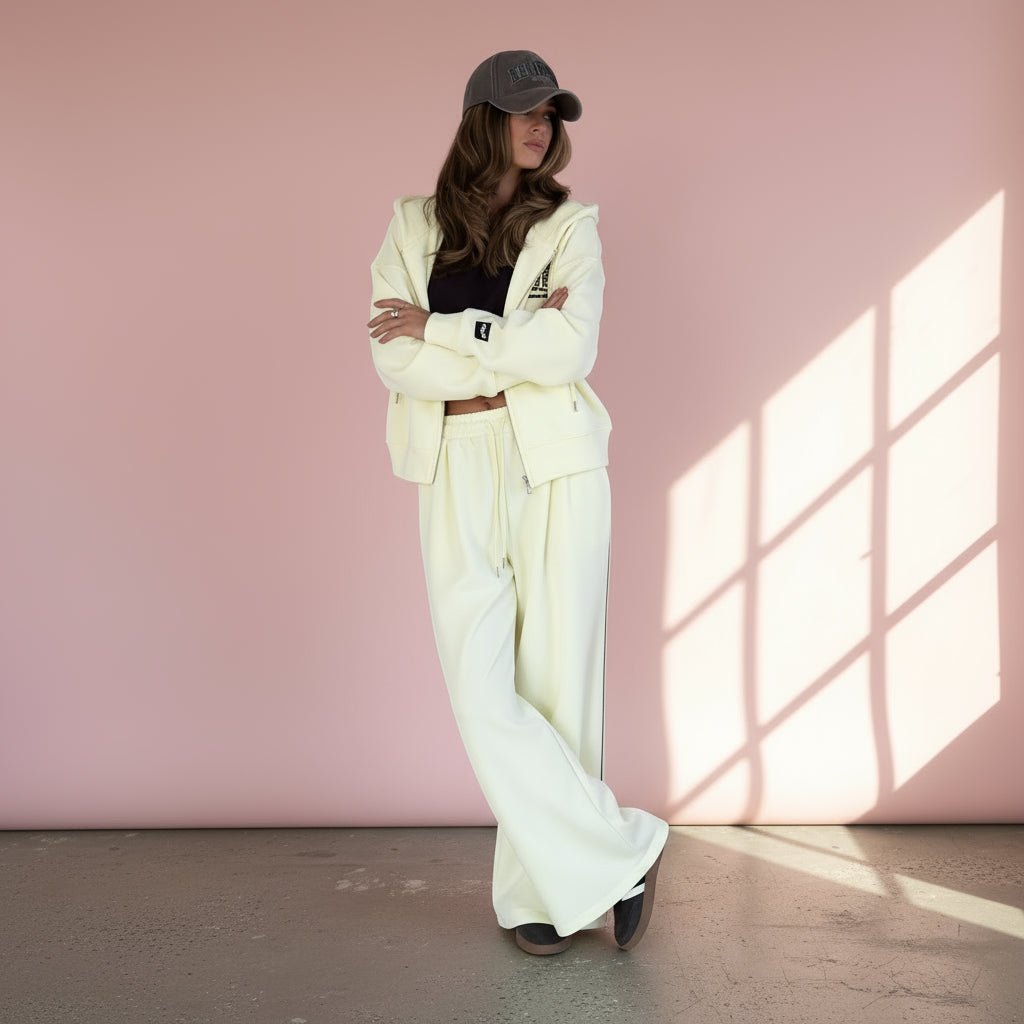 Person wearing a  tracksuit with a black crop top on a gray background