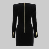 Black dress with gold buttons and zipper on a gray background