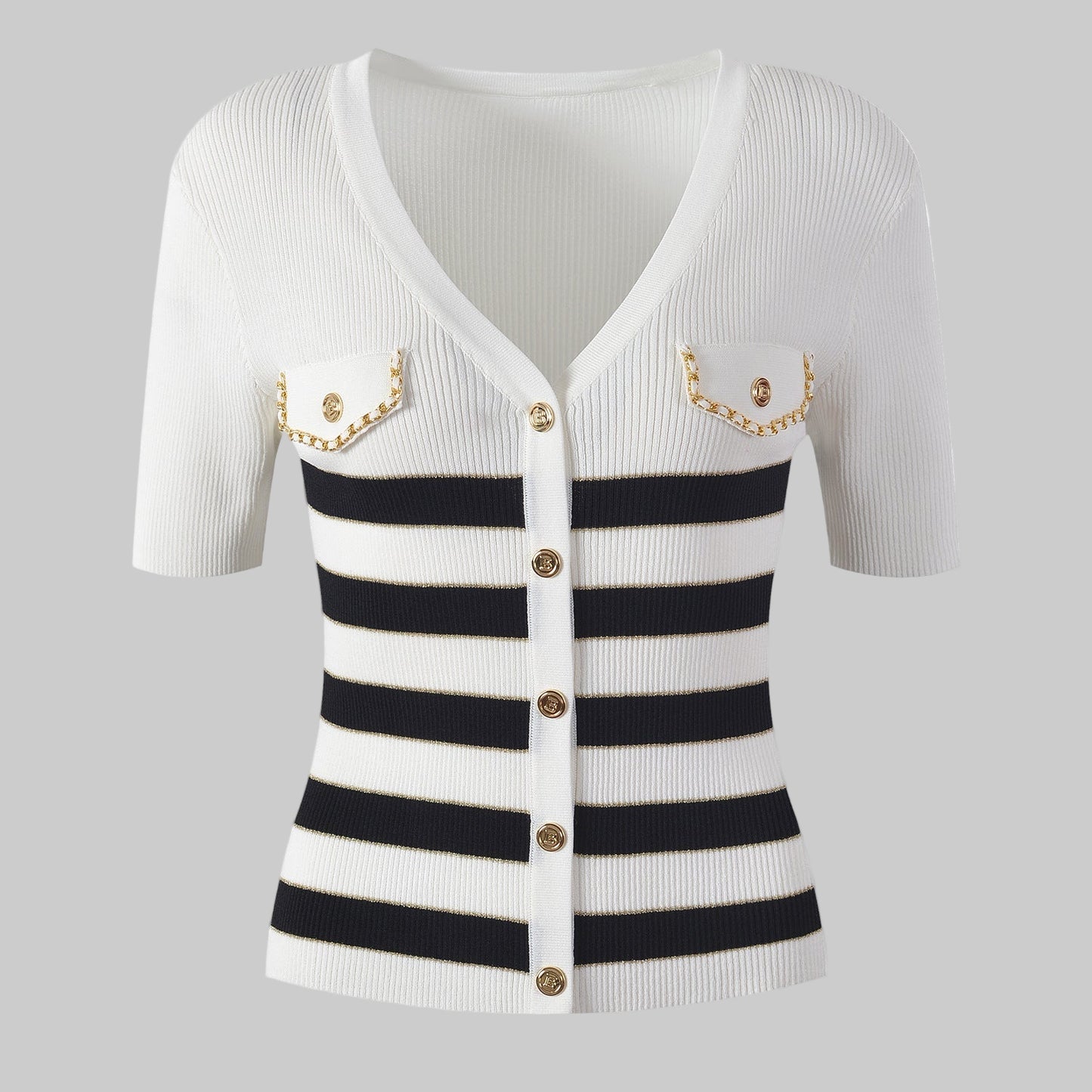 White cardigan with black and white striped pattern and gold buttons on a gray background
