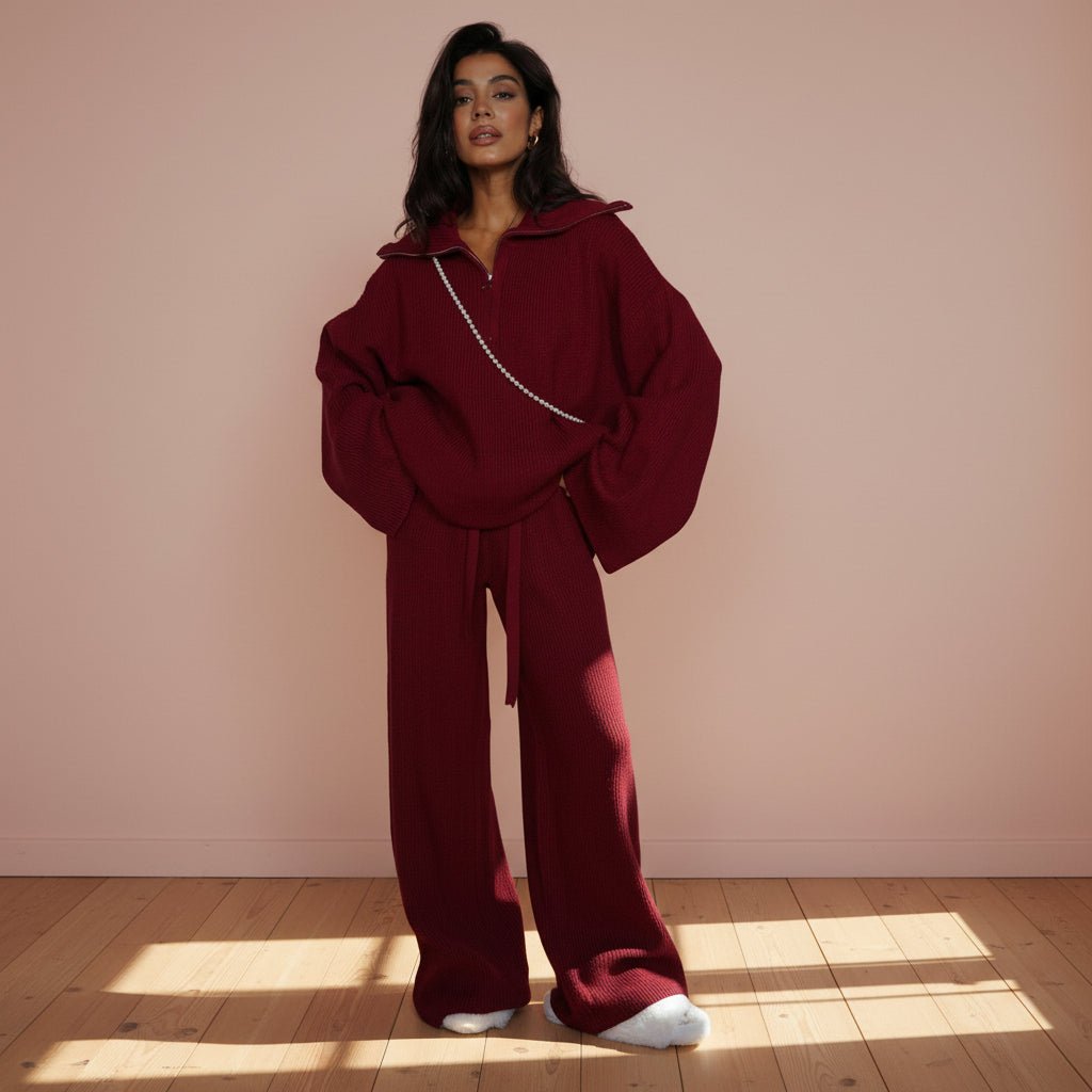 Person wearing a burgundy outfit with a matching jacket and pants on a gray background