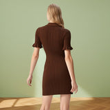 Woman wearing a brown ribbed dress against a gray background