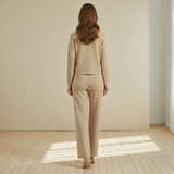 Woman wearing a beige suit on a plain background