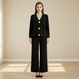 Woman wearing a black suit with gold buttons on a gray background