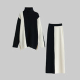 Black and white turtleneck sweater and skirt set on a gray background