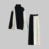Black and white turtleneck sweater and skirt set on a light gray background