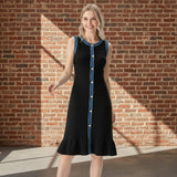 Woman wearing a black dress with blue accents on a gray background