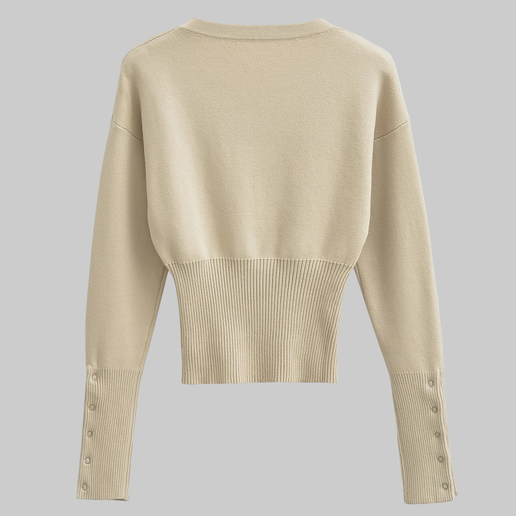 Beige sweater with button details on a gray background