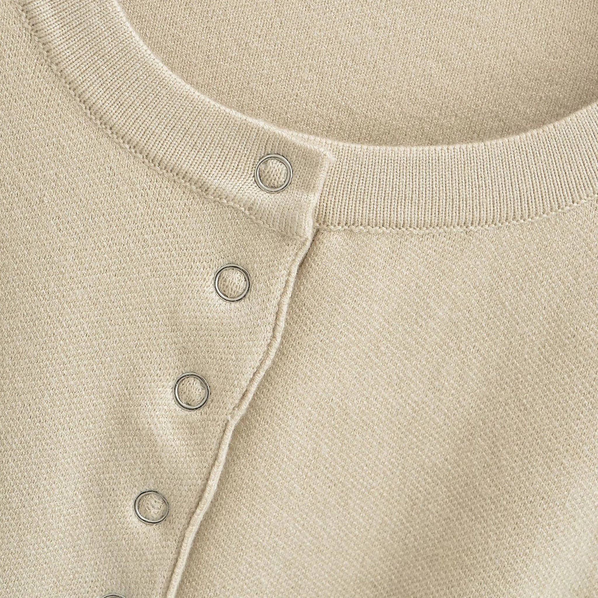 Close-up of a beige sweater with button details