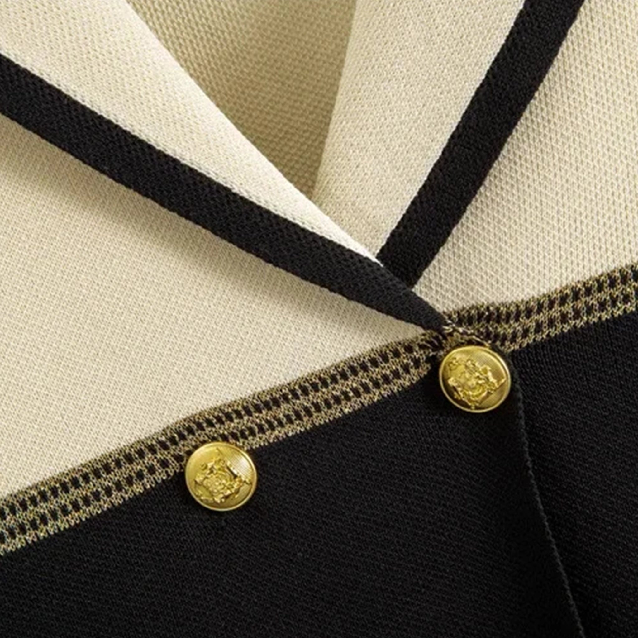 Close-up of a black and beige garment with gold buttons