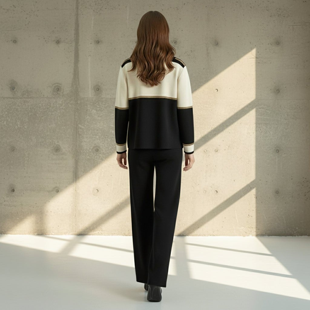 Person wearing a black and white outfit on a gray background