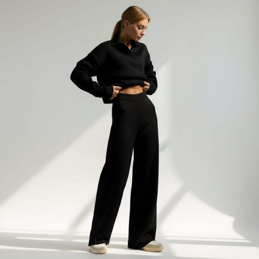 Person wearing a black outfit on a light gray background