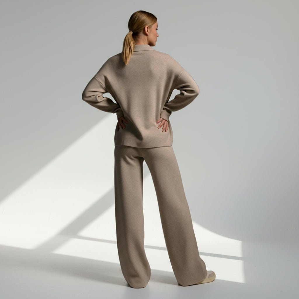 Woman wearing a beige outfit standing in a well-lit room with a neutral background
