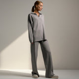 Woman wearing a gray outfit on a plain background