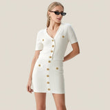 Woman wearing a white dress with gold buttons on a gray background