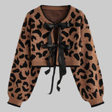 Leopard print cardigan with a black ribbon on a light gray background