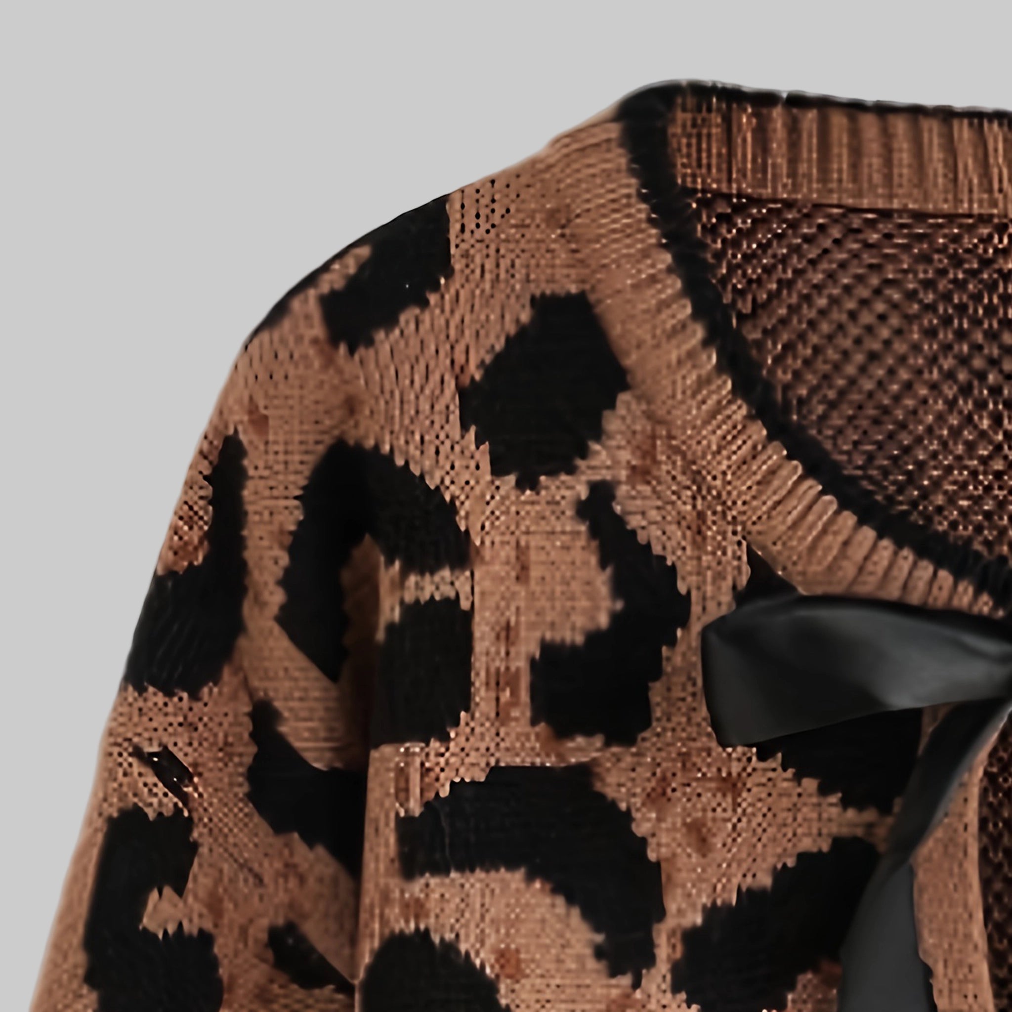 Close-up of a brown sweater with black leopard print pattern on a white background