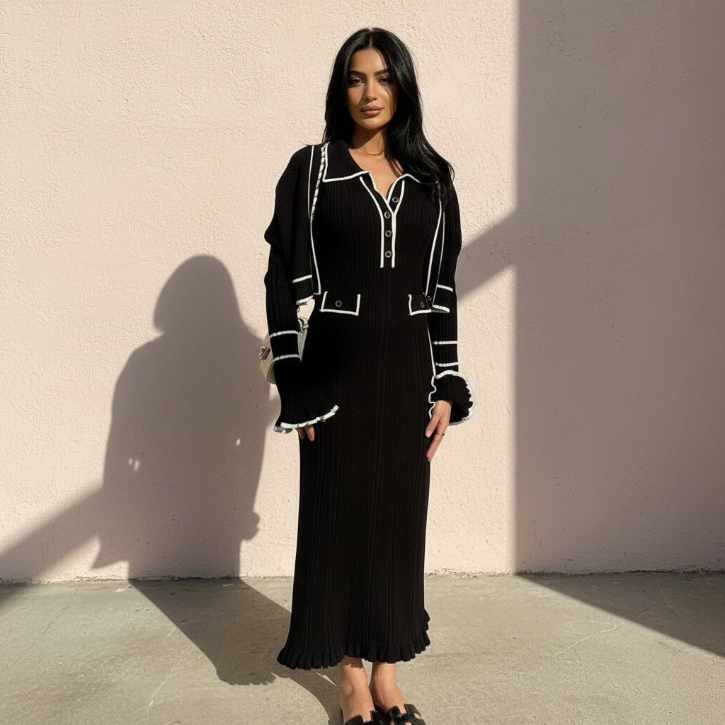 Woman wearing a black dress with white accents on a gray background