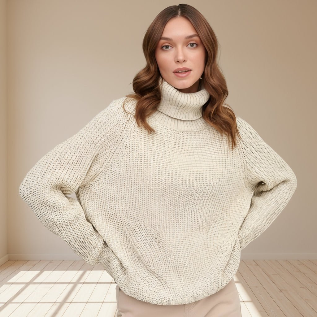 Woman wearing a beige knit sweater against a gray background