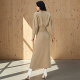 Woman wearing a beige dress on a gray background