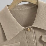 Close-up of a beige textured shirt with a button on a hanger