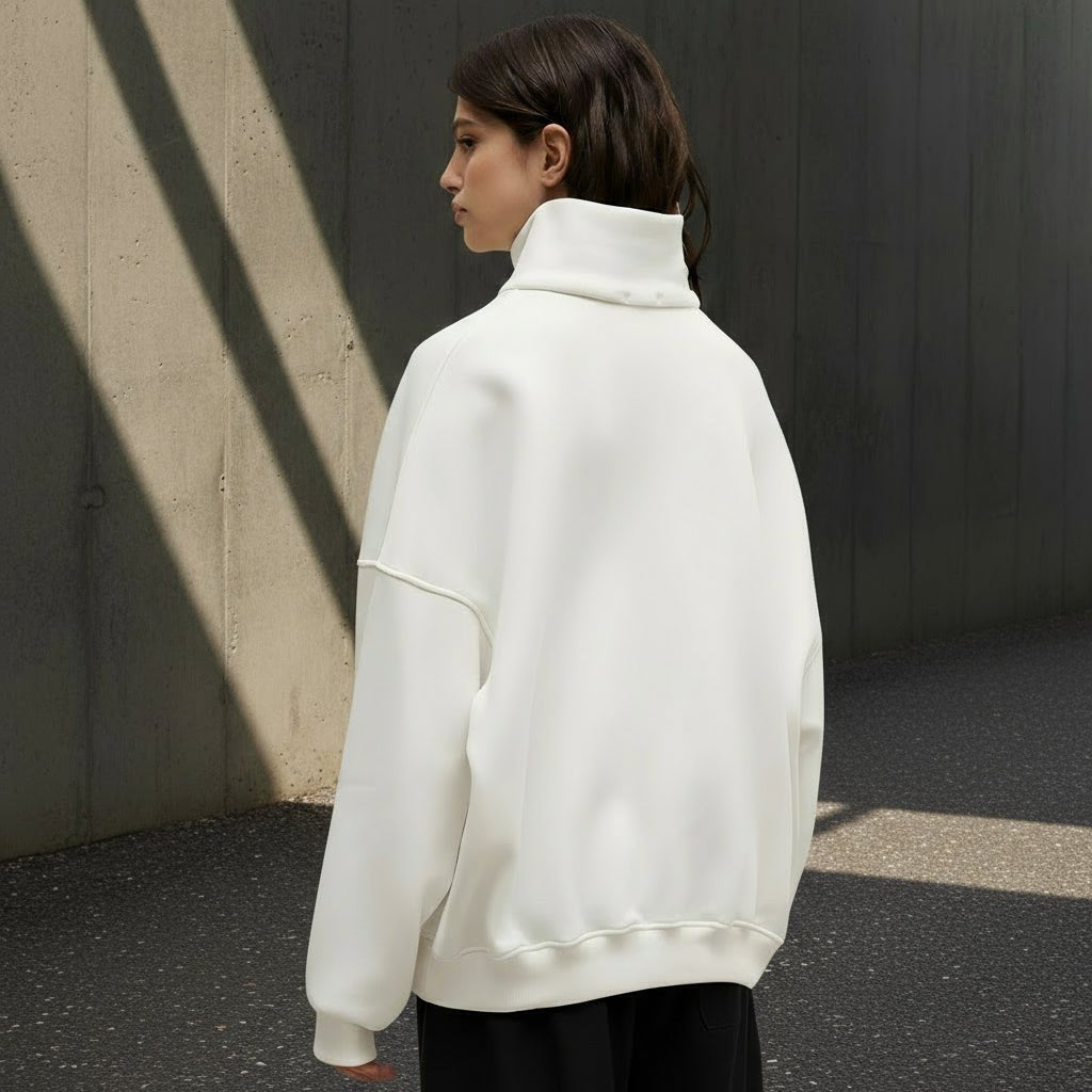 Person wearing a white sweater on a gray background