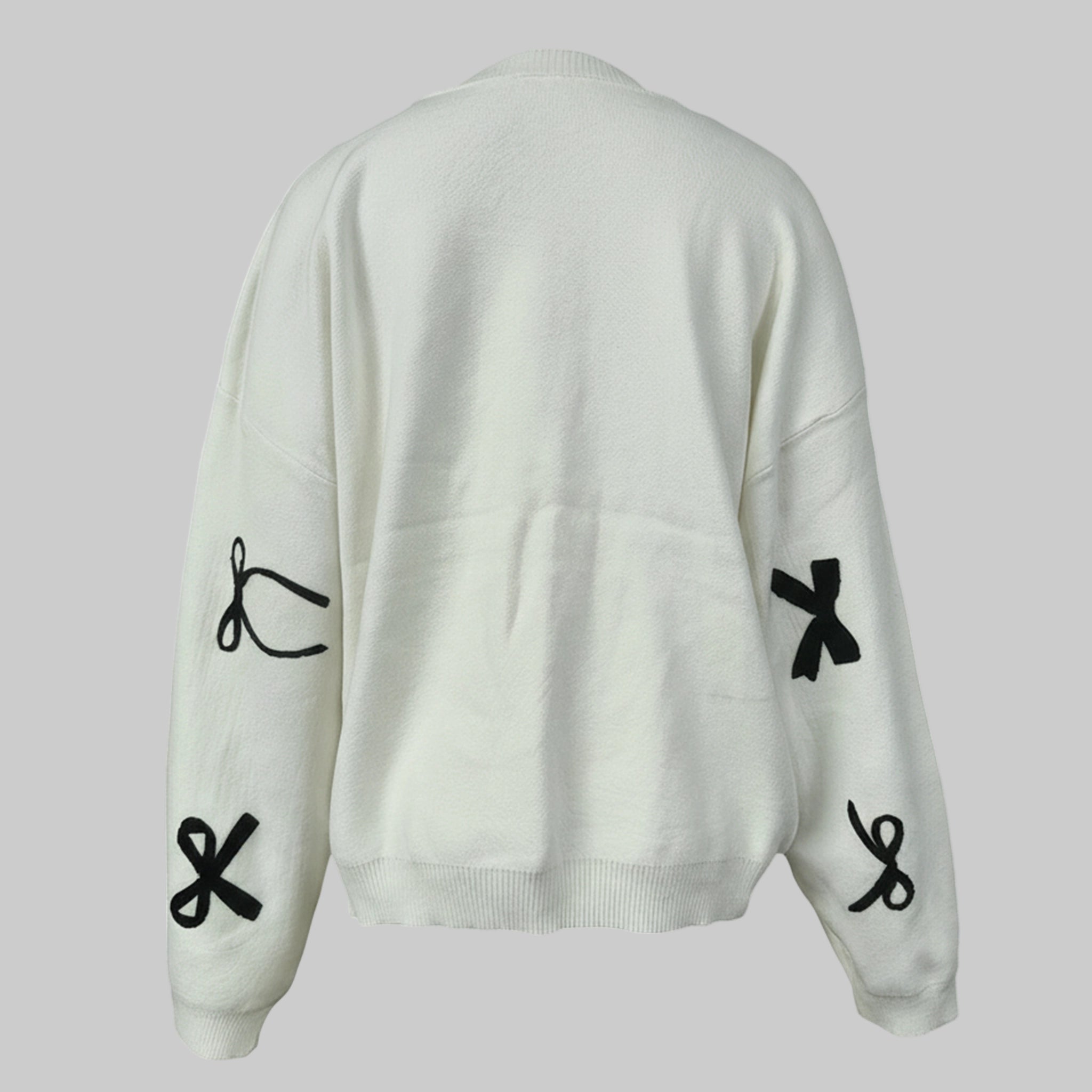 White sweater with black symbol designs on a light gray background
