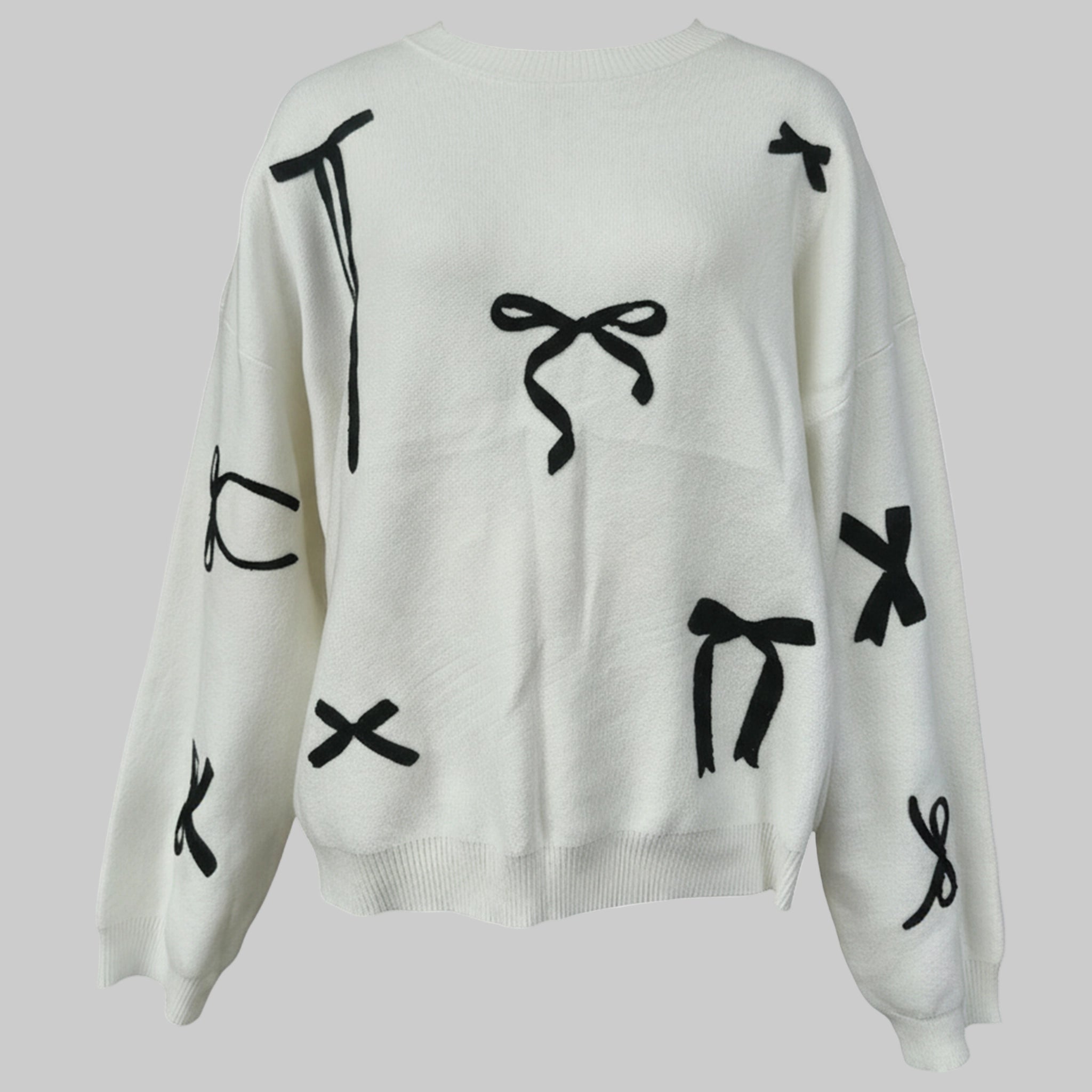White sweater with black abstract designs on a light gray background