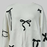 White sweater with black bow patterns on a white background