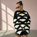 Woman wearing a black and white striped sweater with sunglasses indoors.
