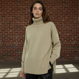 Woman wearing a beige turtleneck sweater on a plain background