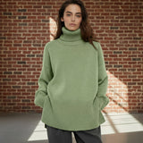 Person wearing a green sweater on a plain background