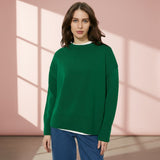 Woman wearing a green sweater on a gray background