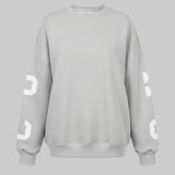 Gray sweatshirt with white lettering on sleeves against a white background
