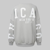 Gray sweatshirt with 'Chicago New York Est. 25' text on a light gray background