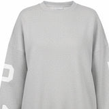 Gray sweatshirt with white lettering on sleeves against a white background
