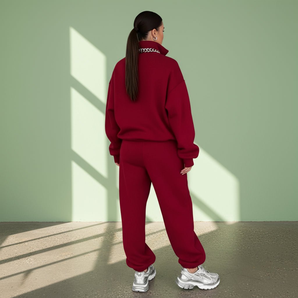 Person wearing a red tracksuit on a gray background