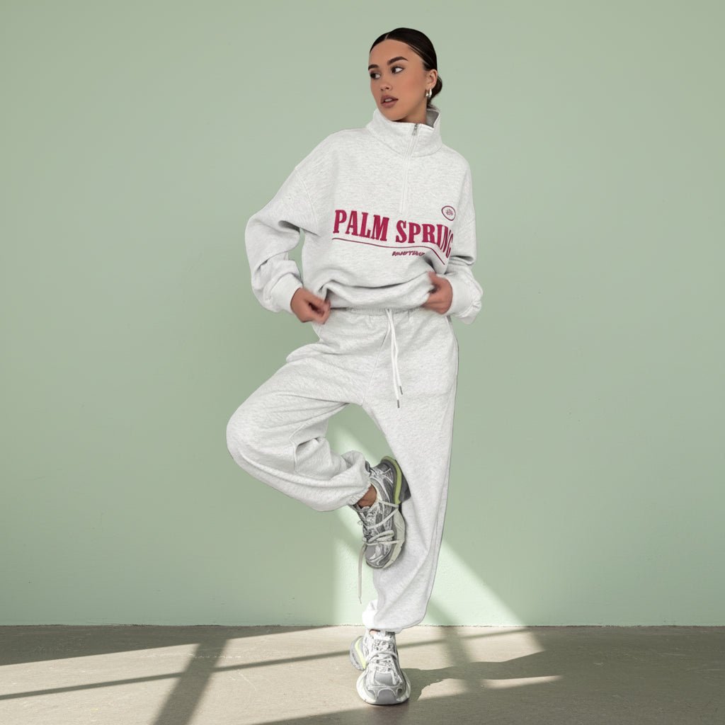 Person wearing a white hoodie with 'Palm Springs' text on a gray background