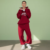 Person wearing a red tracksuit with visible branding on a gray background