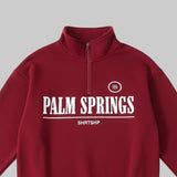 Red half-zip sweatshirt with 'Palm Springs' text on a white background