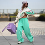 Person wearing a stylish outfit with a purple bag on a city street.