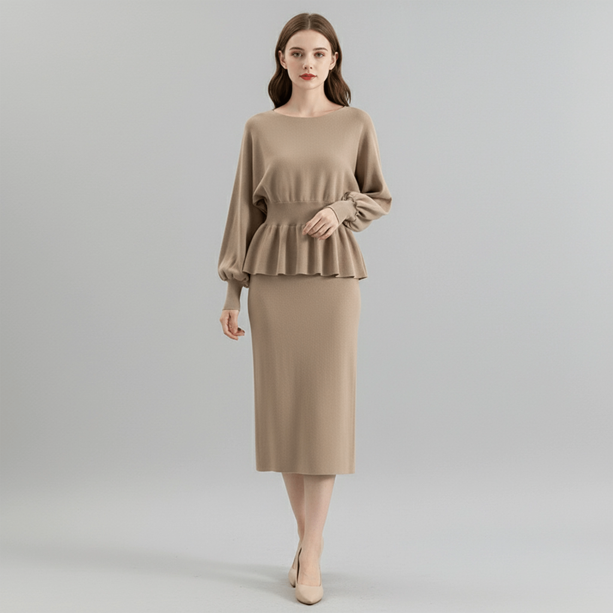 Woman wearing a beige peplum top and skirt on a gray background