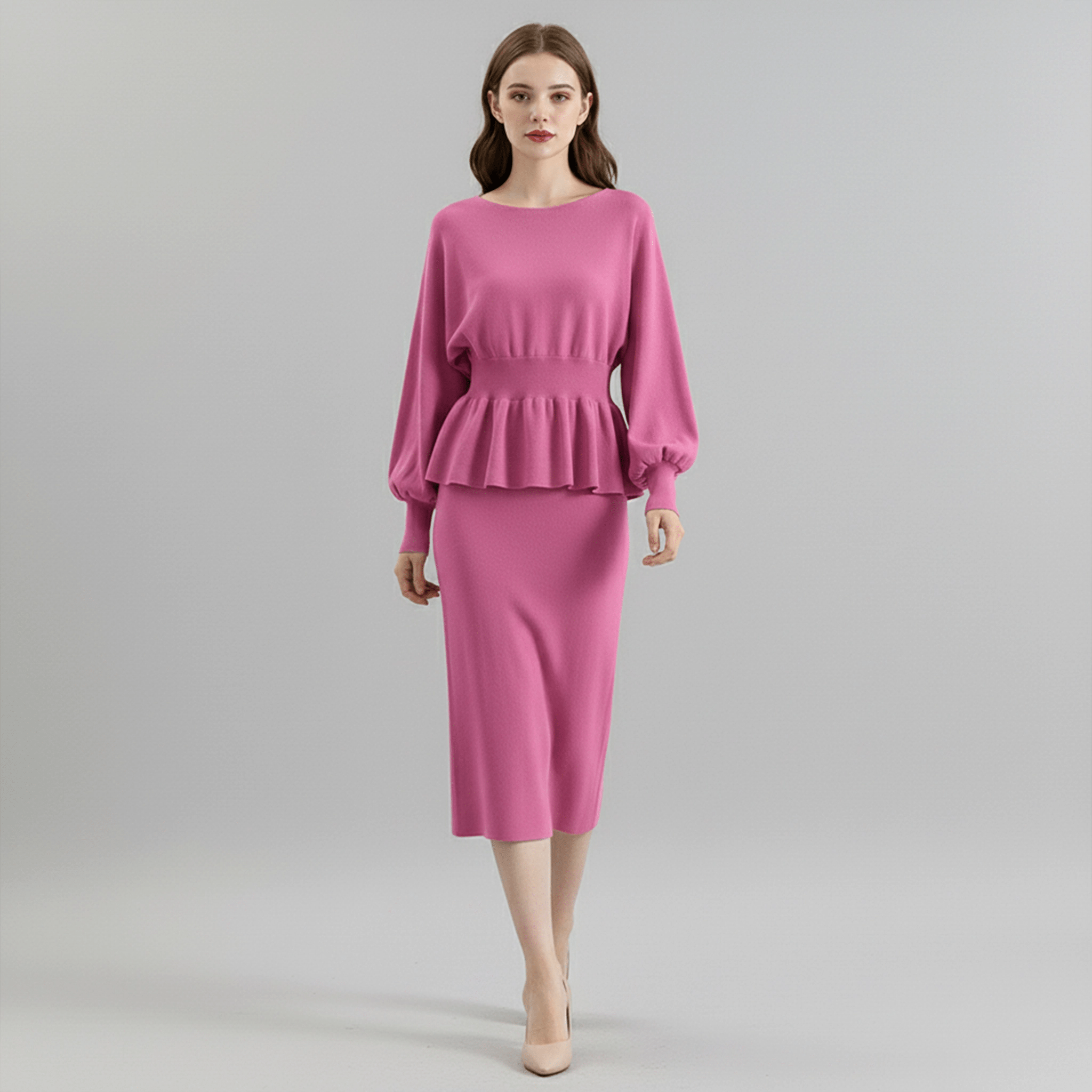 Woman wearing a pink dress with a peplum top on a gray background