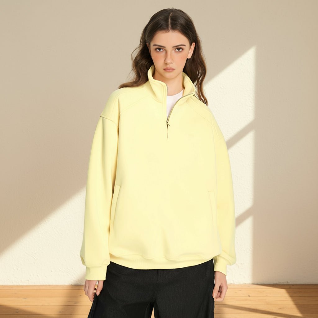 Woman wearing a light yellow pullover with a gray background
