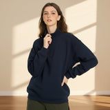 Woman wearing a navy blue hoodie on a gray background