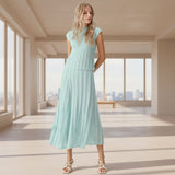 Woman wearing a light blue dress against a gray background