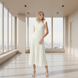 Woman wearing a white dress against a gray background