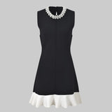 Black dress with white trim on a white background