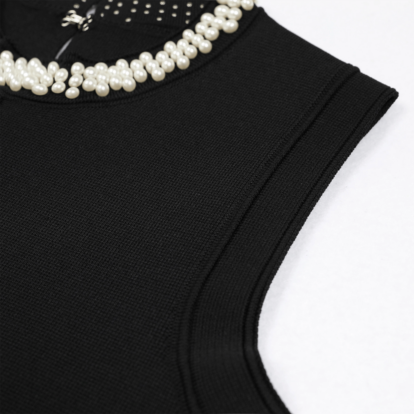 Black sleeveless top with pearl embellishments on a white background