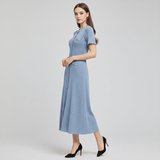 Woman wearing a blue dress on a light gray background