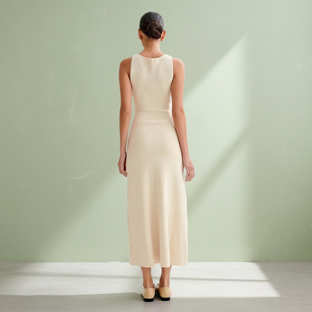 Woman wearing a beige sleeveless dress on a gray background